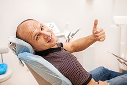 Man giving a thumbs up in dental chair