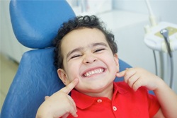 Smiling child in dentist’s chair. 