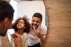 Parent and child brushing their teeth. 