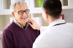 Smiling patient talking to a dentist