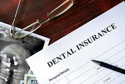 Dental insurance paperwork with glasses and pen on a desk