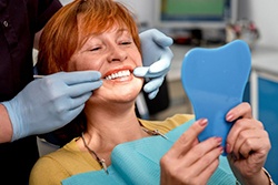 An older woman examining her smile.