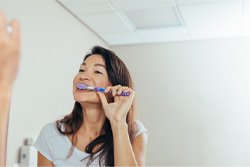 Woman brushing her new dental implants in Plano 