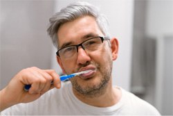 Man brushing his dental implants in Plano   