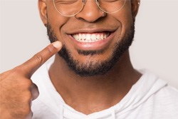 Closeup of man pointing to his new dental implants in Plano 