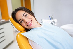 Female dental patient leaning back in chair and smiling