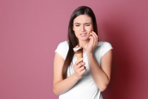 a woman with sensitive teeth trying to eat ice cream