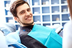 young man in dental chair smiling visiting dentist in plano